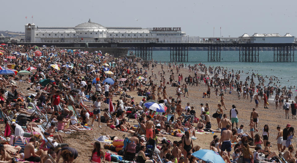 Beachgoers enjoy the sunshine and sea on what is now Britain's hottest day of the year so far, in Brighton, England, Friday, July 31, 2020. Temperatures have reached 35C (95F) at London's Heathrow Airport. (AP Photo/Alastair Grant)