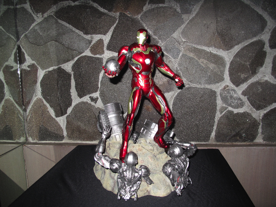 Iron Man holds Ultron in his hand.