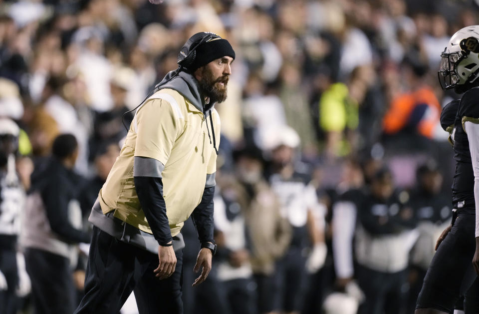 Colorado co-offensive coordinator Sean Lewis, left, talks to quarterback Shedeur Sanders during a break in play in the second half of the team's NCAA college football game against Oregon State on Saturday, Nov. 4, 2023, in Boulder, Colo. (AP Photo/David Zalubowski)