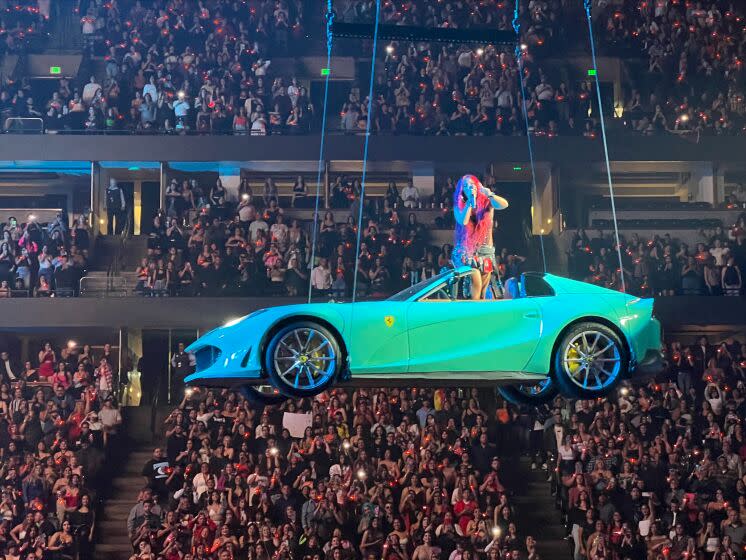 Karol G abordo de su Ferrari en lo lato del Honda Center de Anaheim durante su llegada a la ciudad como parte de su gira "$trip Love Tour".