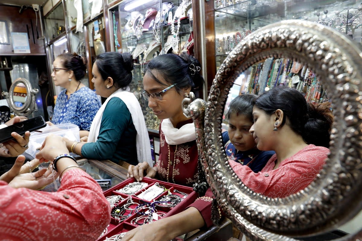 Staff assist customers at a jewelry store at New Market in Kolkata on 19 September (EPA)