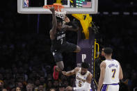 Orlando Magic guard Kevon Harris (7) hangs from the rim after dunking over Los Angeles Lakers guard Malik Beasley (5) during the first half of an NBA basketball game Sunday, March 19, 2023, in Los Angeles. (AP Photo/Marcio Jose Sanchez)