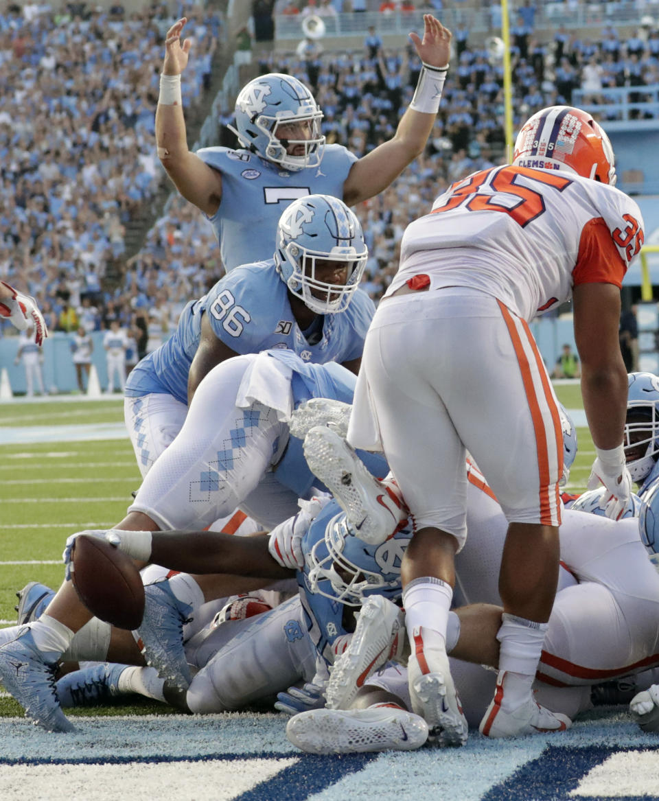 North Carolina Tar Heels's Sam Howell (7) signals for a touchdown as J.C. Chalk (25) crosses the line to score late in the fourth quarter of an NCAA college football game against Clemson in Chapel Hill, N.C., Saturday, Sept. 28, 2019. North Carolina's Carl Tucker (86) and Clemson Justin Foster (35) are also in on the play. (AP Photo/Chris Seward)