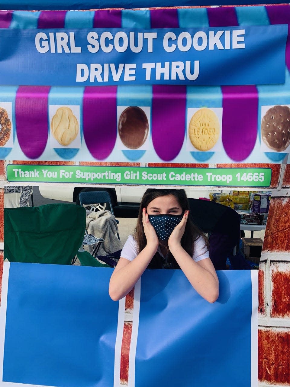 A Girl Scout Cadette of Troop 14665, located in the Atlanta area, awaits customers in their drive-thru cookie stand.