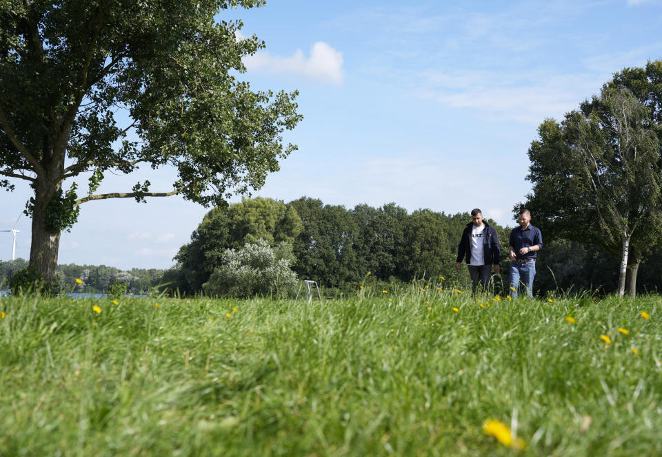 U.S. Army veteran Spencer Sullivan, right, and Abdulhaq Sodais, who served as a translator in Afghanistan, walk in a park in Bremen, Germany, Saturday, Aug. 14, 2021. Sullivan is trying to help Sodais get asylum after he had to flee to Germany. (AP Photo/Peter Dejong)