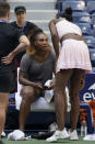 Serena Williams, left, talks with her sister Venus Williams after Serena finished practicing at Arthur Ashe Stadium before the start of the U.S. Open tennis tournament in New York, Thursday, Aug. 25, 2022. (AP Photo/Seth Wenig)