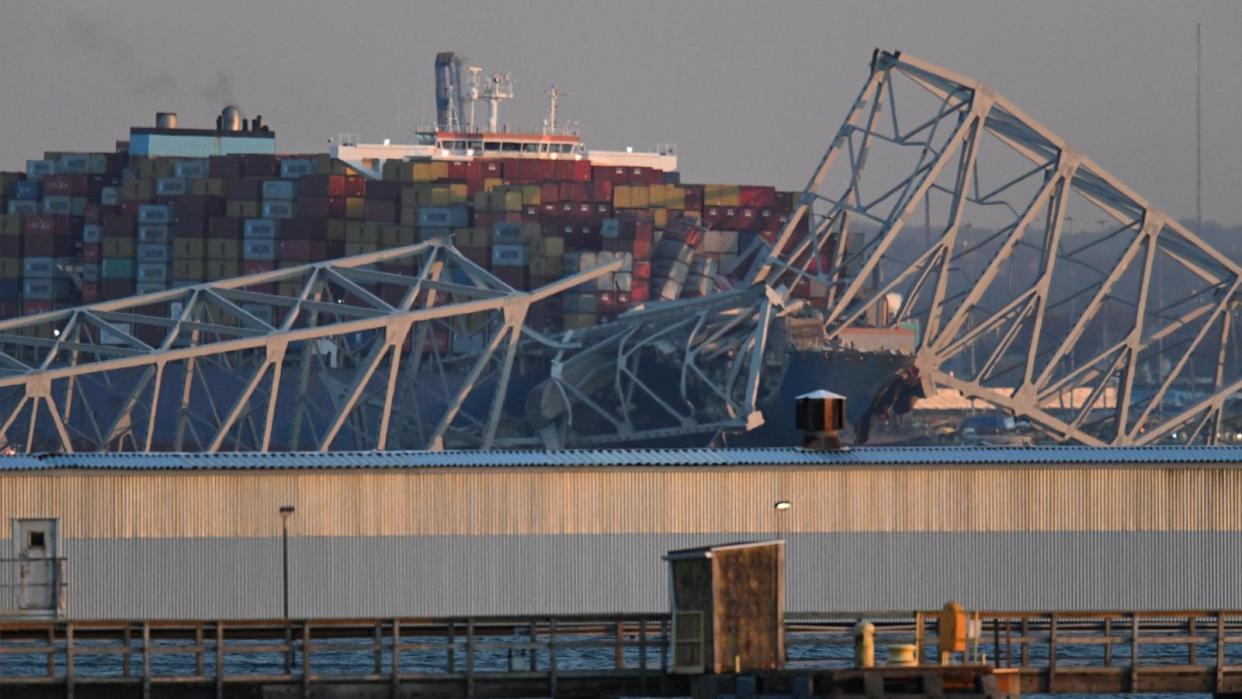 PHOTO: The steel frame of the Francis Scott Key Bridge sits on top of a container ship after it struck the bridge in Baltimore on March 26, 2024. (Roberto Schmidt/AFP via Getty Images)