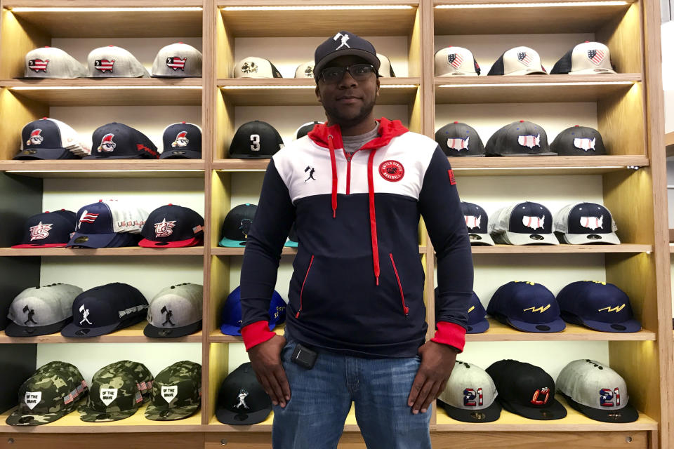 Baseballism store manager Thomas Brown poses Thursday, Oct. 28. 2021, in Atlanta. Brown expects one of the busiest weeks of the year at Baseballism, which sells baseball apparel and other gear related to the national pastime at The Battery, just outside the Atlanta Braves' stadium in Cobb County, Ga. (AP Photo/Jeff Martin)