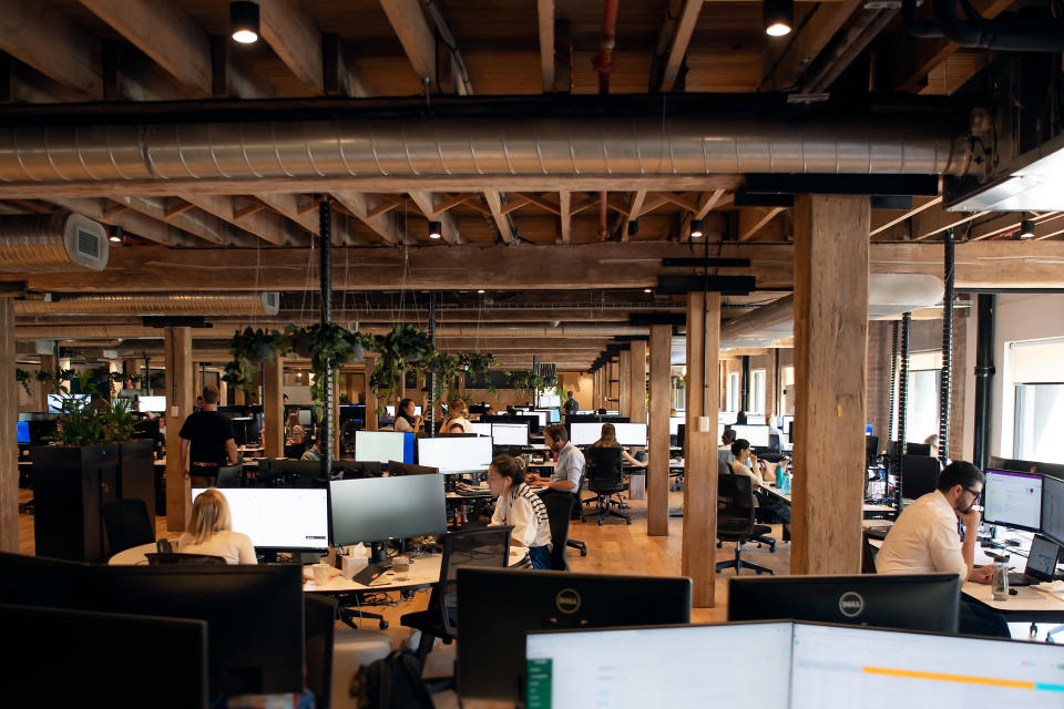 A large office environment with people sitting working at desktop computers