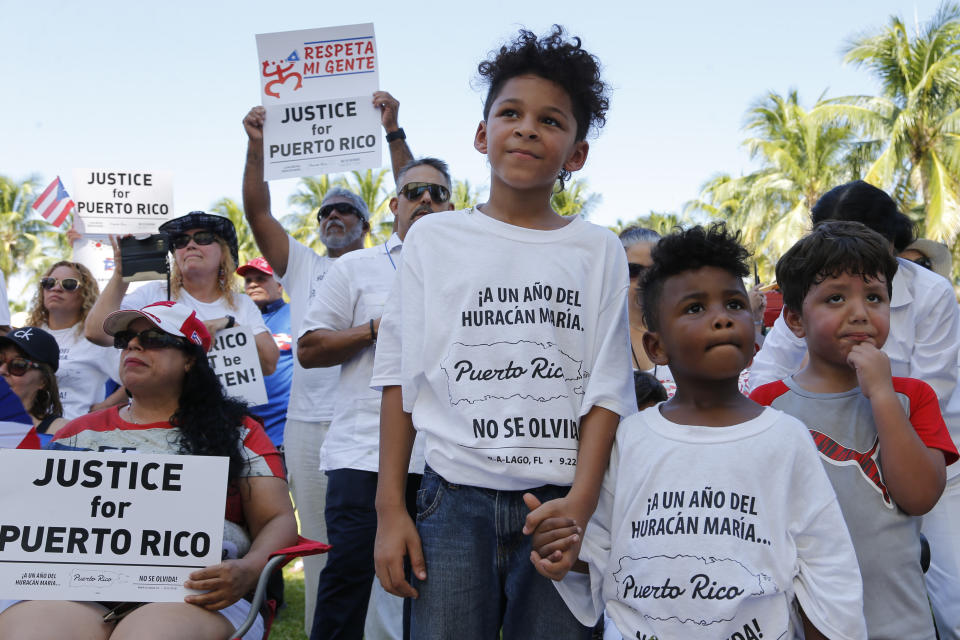 Hector Rivera, 8, Mario Jordan Micael, 3, and Ramon Montes, 5, participate in a rally in West Palm Beach, Fla., on Saturday, Sept. 22, 2018, marking the one-year anniversary of Hurricane Maria's devastation of Puerto Rico. (AP Photo/Ellis Rua)