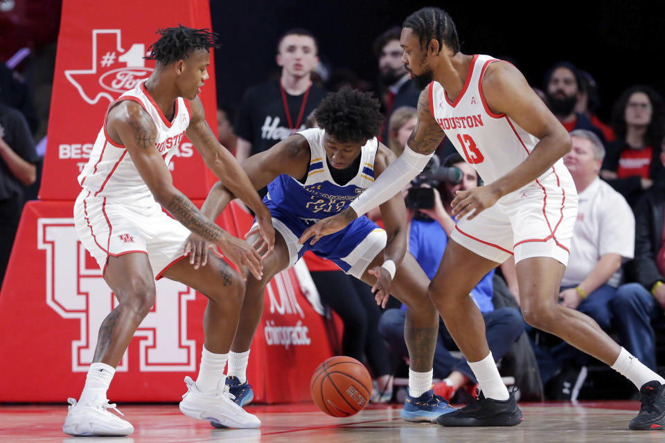 McNeese State guard Harwin Francois, center, loses the ball under pressure from Houston guard Marcus Sasser, left, and forward J'Wan Roberts (13) during the first half of an NCAA college basketball game Wednesday, Dec. 21, 2022, in Houston. (AP Photo/Michael Wyke)