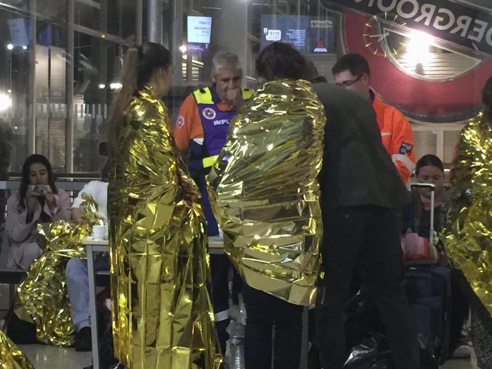 Passengers wrapped in thermal foil blankets given out by emergency services after their Eurostar train was stranded at Calais Station, after intruders were seen near the Eurotunnel, in Calais, France September 2, 2015. Hundreds of passengers were stranded for hours on five Eurostar high-speed trains after reports that migrants were blocking the tracks leading to the tunnel under the English Channel and were attempting to climb aboard. REUTERS/John Pullman