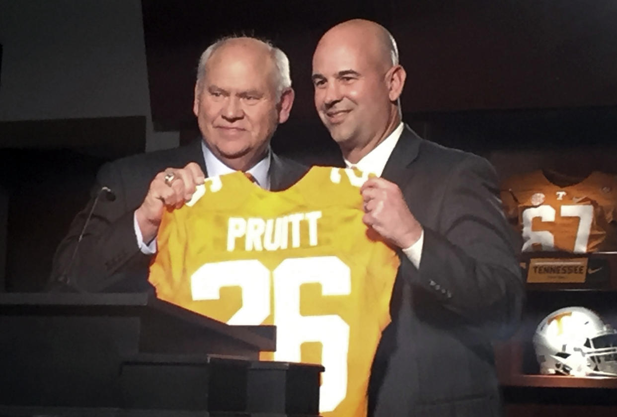 FILE - New Tennessee football coach Jeremy Pruitt, right, receives a personalized jersey from athletic director Phillip Fulmer during his introductory news conference in Knoxville, Tenn., in this Thursday, Dec. 7, 2017, file photo. Tennessee fired Pruitt Monday, Jan. 18, 2021. The university also announced Monday that Phillip Fulmer will retire as athletic director.  (AP Photo/Steve Megargee, FIle)