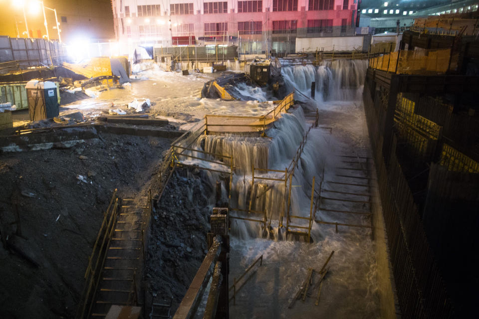 FILE - In this Oct. 29, 2012 file photo, sea water floods the World Trade Center construction site in New York during Superstorm Sandy. A study released in the journal Nature Communications on Tuesday, May 18, 2021, says climate change added $8 billion to the massive costs of 2012's Superstorm Sandy. (AP Photo/John Minchillo, File)