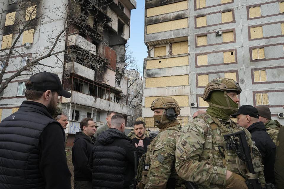 Ukraine's President Volodymyr Zelenskyy, center, visits a missile-damaged area in Zaporizhzhia, Ukraine, Monday, March 27, 2023. Zelenskyy has been increasing his travel across Ukraine as his country's war with Russia enters its second year. A team of journalists from The Associated Press traveled with Zelenskyy aboard his train for two nights as he visited troops along the front lines and communities that have been liberated from Russian control. (AP Photo/Efrem Lukatsky)