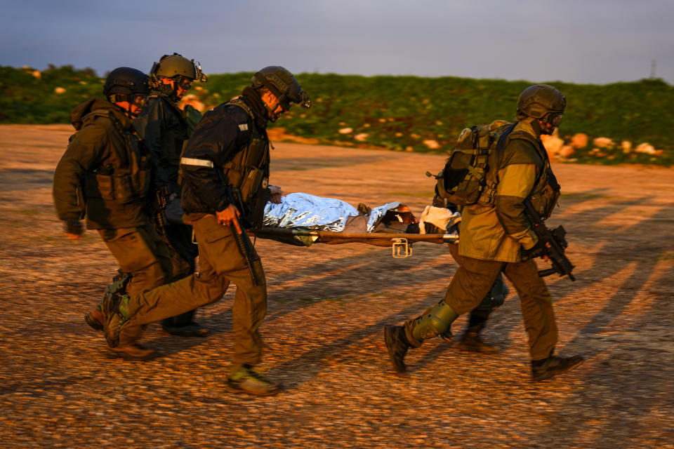 Israeli soldiers run as they carry a stretcher towards a military helicopter during an exercise simulating evacuation of wounded people in northern Israel, near the border with Lebanon, Tuesday, Feb. 20, 2024. (AP Photo/Ariel Schalit)