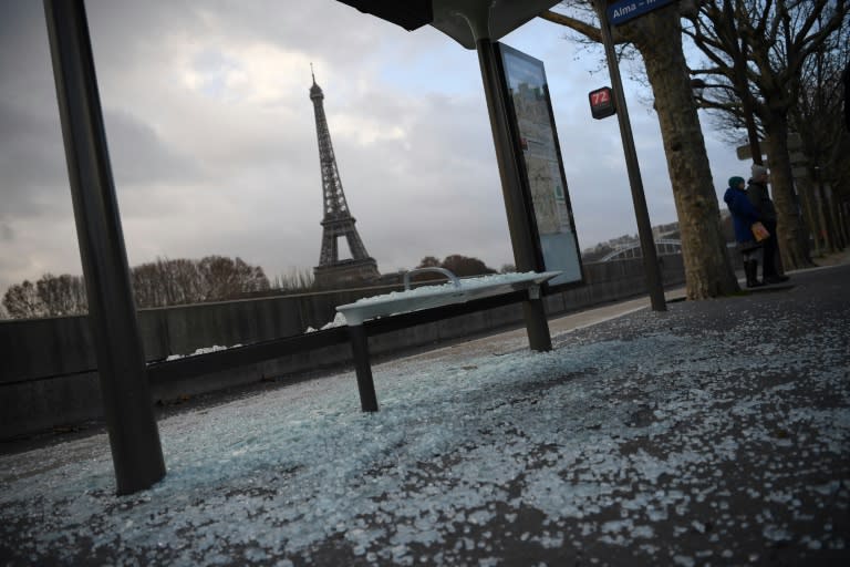 Cleaners swept up broken glass from smashed shop windows and bus stops across Paris on Sunday