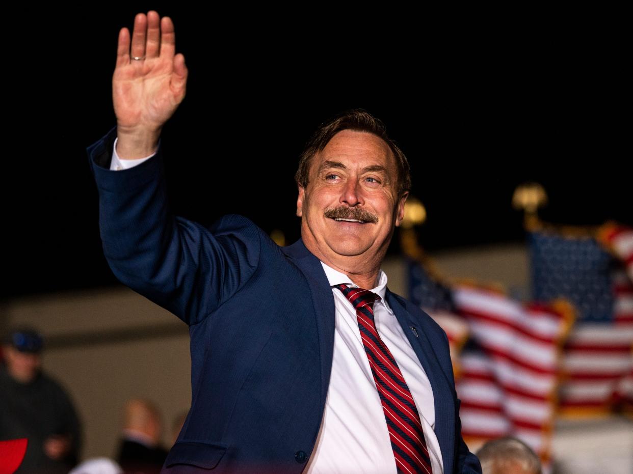 MyPillow CEO Mike Lindell waves as he is introduced while former U.S. President Donald Trump speaks during a campaign event at Sioux Gateway Airport on November 3, 2022 in Sioux City, Iowa.