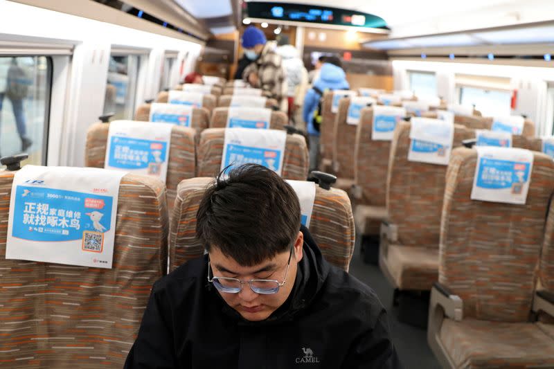 Zhang Baichuan rides a train at a railway station in Beijing