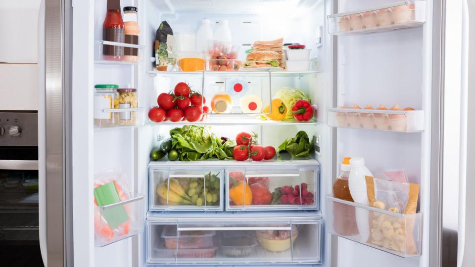 Refrigerator full of produce and groceries
