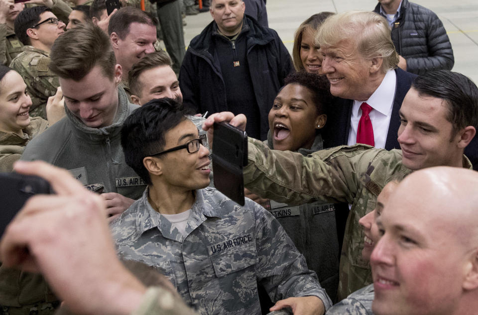 FILE - In this Thursday, Dec. 27, 2018 file photo, President Donald Trump, center right, and first lady Melania Trump, center left, greet members of the military at Ramstein Air Base, Germany. After more than a year of thinly veiled threats that the United States could start pulling troops out of Germany unless the country increases its defense spending to NATO standards, President Donald Trump appears to be going ahead with the hardball approach with a plan to reduce the American military presence in the country by more than 25 percent. (AP Photo/Andrew Harnik, file)