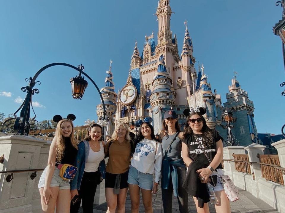 josephine and her friends posing in front of disney world castle during a vip tour