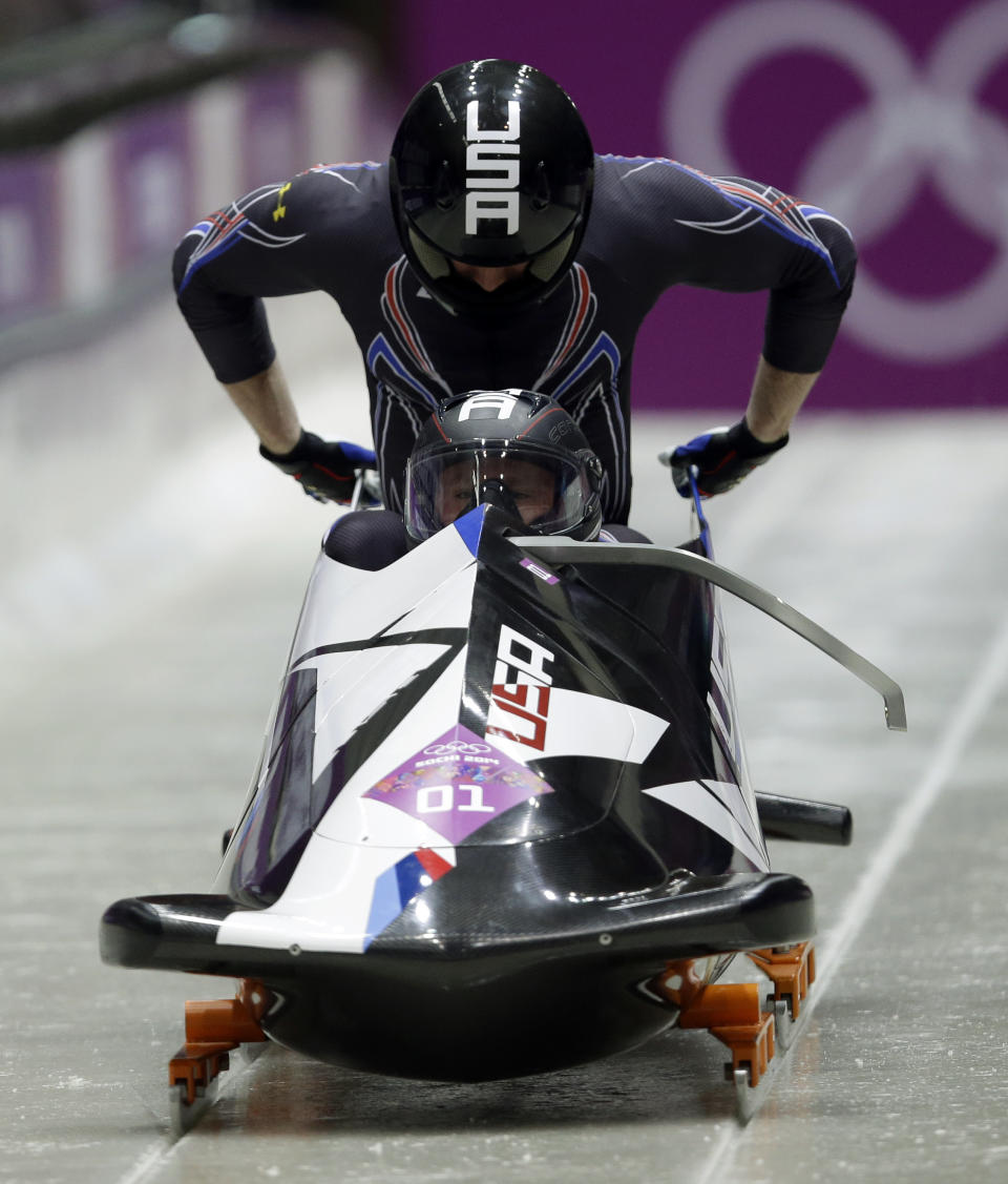 The team from the United States USA-1, piloted by Steven Holcomb and brakeman Steven Langton, start their first run during the men's two-man bobsled competition at the 2014 Winter Olympics, Sunday, Feb. 16, 2014, in Krasnaya Polyana, Russia. (AP Photo/Dita Alangkara)