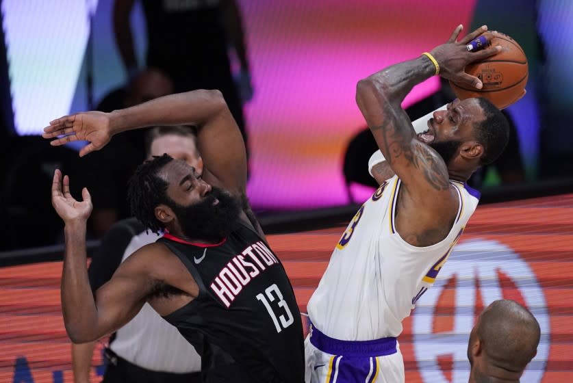 Los Angeles Lakers' LeBron James, right, shoots over Houston Rockets' James Harden (13) during the second half of an NBA conference semifinal playoff basketball game Tuesday, Sept. 8, 2020, in Lake Buena Vista, Fla. (AP Photo/Mark J. Terrill)