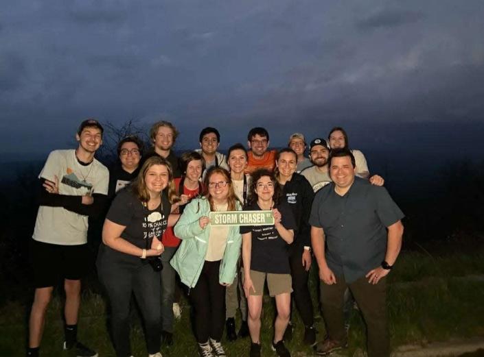 Gavin Short, orange shirt, and Nicholas Nair, left of Short, are pictured with their friends. Short and Nair died in a fatal car crash while coming home after storm chasing in Kansas.