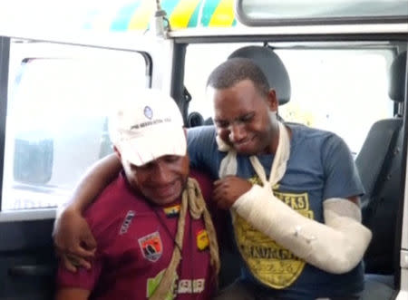 An injured man is helped into a hospital, during clashes between protesters and police in Port Moresby, Papua New Guinea, June 8, 2016.