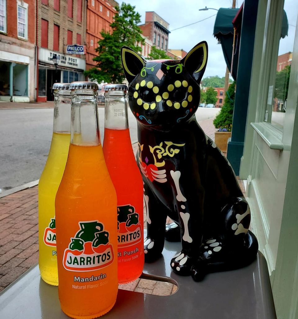 Kathleen "Kat" McCay's ceramic cat poses with bottles of Jarritos soft drinks which will be sold at Loco Kitty in Old Towne Petersburg late this summer.