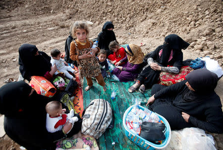 Iraqi women and children sit near the berm after escaping from the Islamic State-controlled village of Abu Jarboa, Iraq October 31, 2016. REUTERS/Azad Lashkari