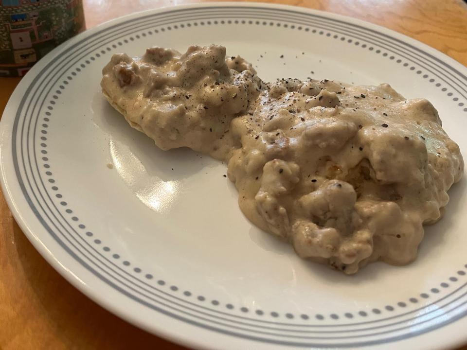 plate of homemade biscuits and gravy on a kitchen table