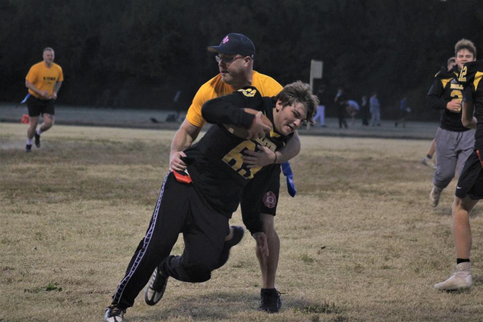 Bellevue junior Jackson Day tries to evade a defender as Bellevue's varsity football team played a flag football game Friday against members of the Bellevue police department and other adult members of the community.