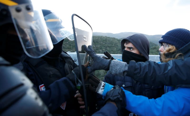 Members of Catalan protest group Democratic Tsunami clash with French police officers at the AP-7 highway