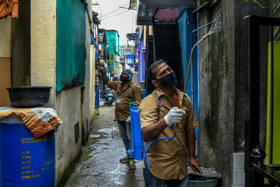 Workers from the Pune Municipal Corporation spray disinfectant in the Tadiwala Chawl area.<span class="copyright">Atul Loke for TIME</span>