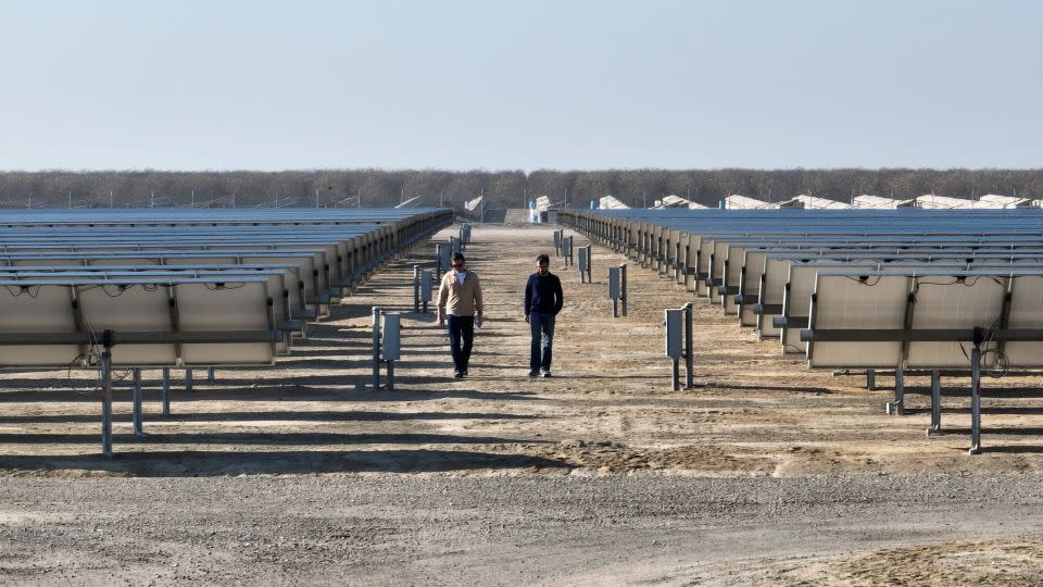 Bill (left) walks through a solar array with Antora Energy's co-founder and CEO. The company is developing new ways to store clean energy. - Julian Quinones/CNN
