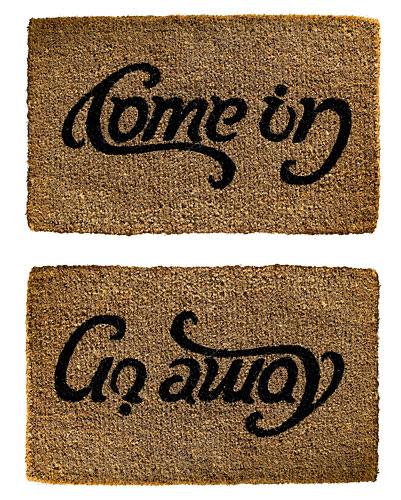 brown doormat that says come in and then go away depending on the angle