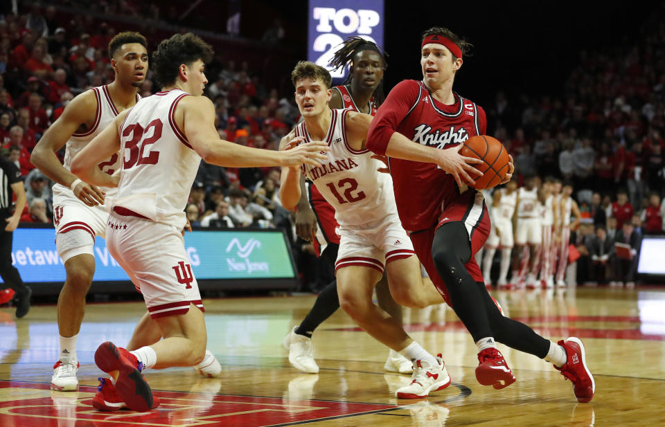 Rutgers guard Paul Mulcahy, right, drives to the basket against Indiana forward Miller Kopp (12) and Trey Galloway (32) during the second half of an NCAA college basketball game in Piscataway, N.J., Saturday, Dec. 3, 2022. (AP Photo/Noah K. Murray)
