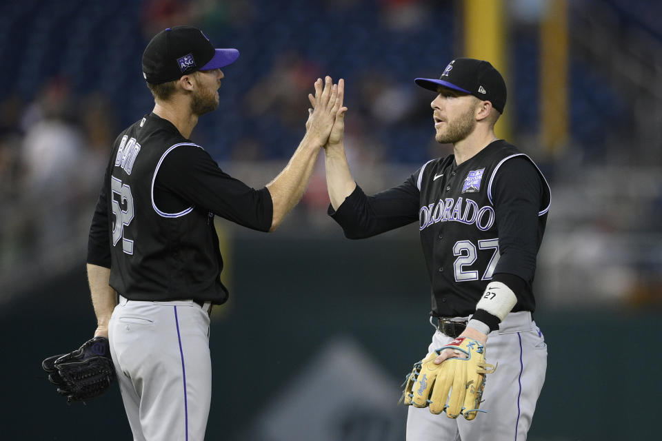 Colorado Rockies' Trevor Story (27) celebrates with Daniel Bard (52) after a baseball game against the Washington Nationals, Saturday, Sept. 18, 2021, in Washington. (AP Photo/Nick Wass)