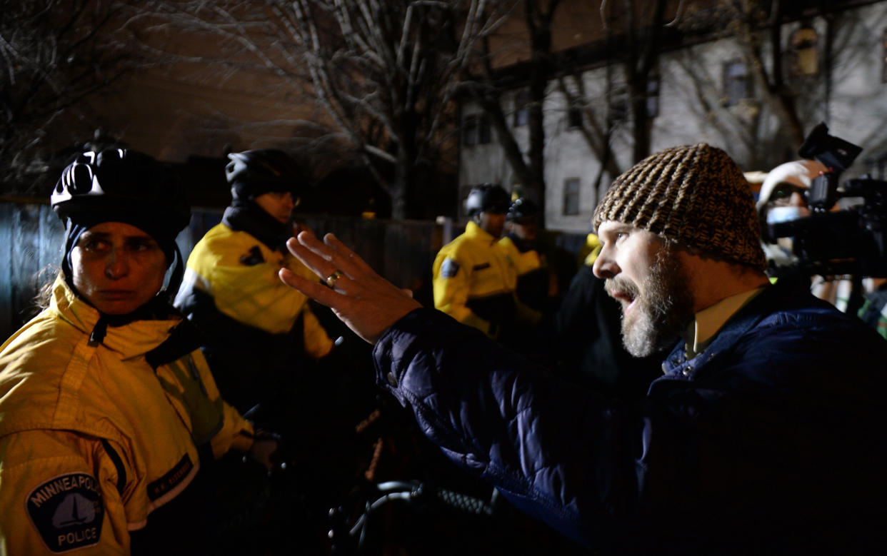 Pastor Tanden Brekke, right, pleads with officers to deescalate the situation as demonstrators besiege the Minneapolis Police Department Fourth Precinct building on Wednesday. Protesters have been camping outside the building since the fatal police shooting of Jamar Clark. (John Autey/Pioneer Press via AP)