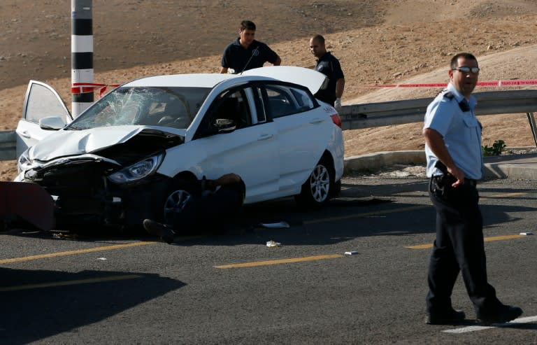 Israeli security forces stand at the site where a Palestinian rammed his car into Israelis soldiers standing by a bus station near the Jewish settlement of Kfar Adumim in the occupied West Bank, on November 27, 2015