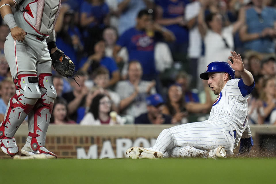 Chicago Cubs' Michael Busch slides into home to score on a single from Cody Bellinger during the seventh inning of a baseball game against the Philadelphia Phillies, Wednesday, July 3, 2024, in Chicago. (AP Photo/Erin Hooley)