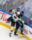 Minnesota Wild's Jordan Greenway (18) hits Vancouver Canucks' Alexander Edler (23) during the third period of an NHL hockey playoff game in Edmonton, Alberta, Tuesday, Aug. 4, 2020. (Codie McLachlan/The Canadian Press via AP)