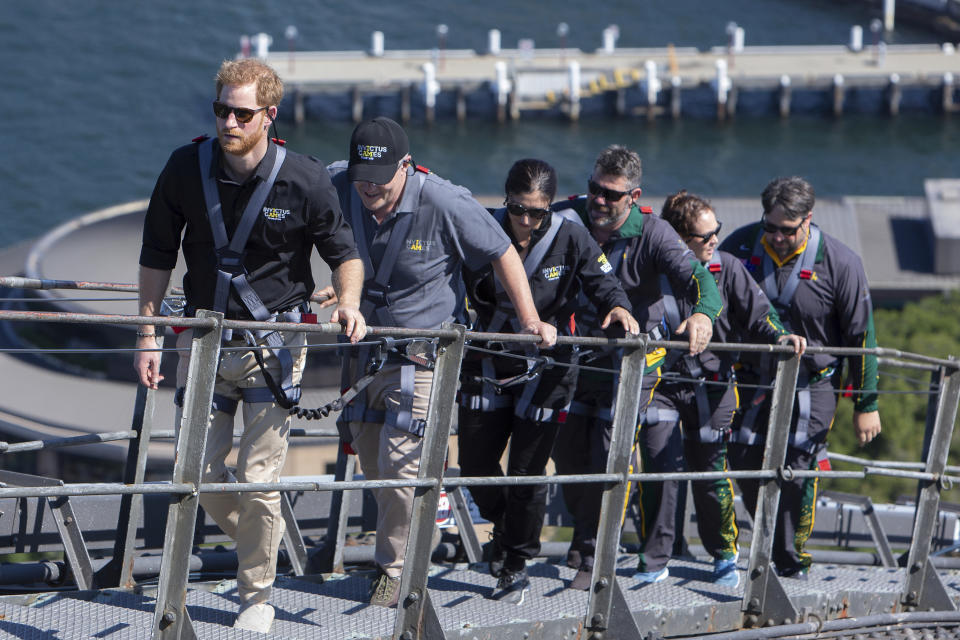 CAPTION CORRECTS THE DATE - Britain's Prince Harry, left, Australia's Prime Minister Scott Morrison, second from left, and Invictus Games representatives climb the Sydney Harbour Bridge in Sydney, Friday, Oct. 19, 2018. Prince Harry and his wife Meghan are on day four of their 16-day tour of Australia and the South Pacific. (AP Photo/Steve Christo, Pool)