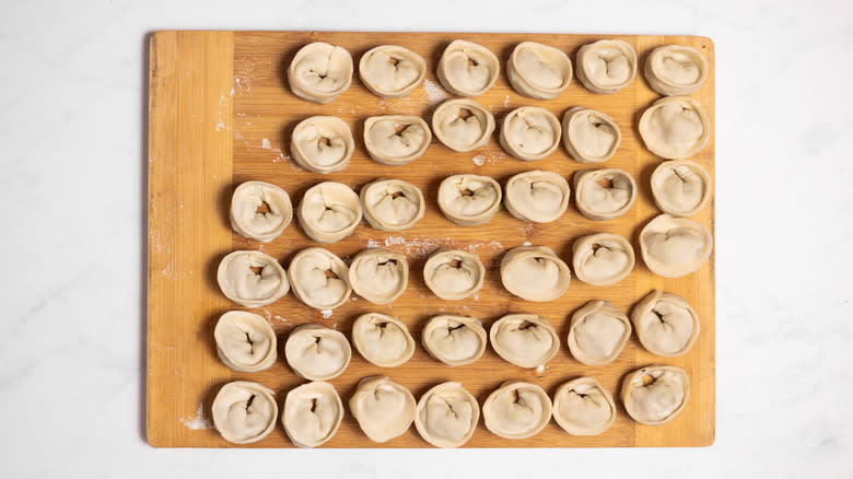 wrapped wontons on wooden board 