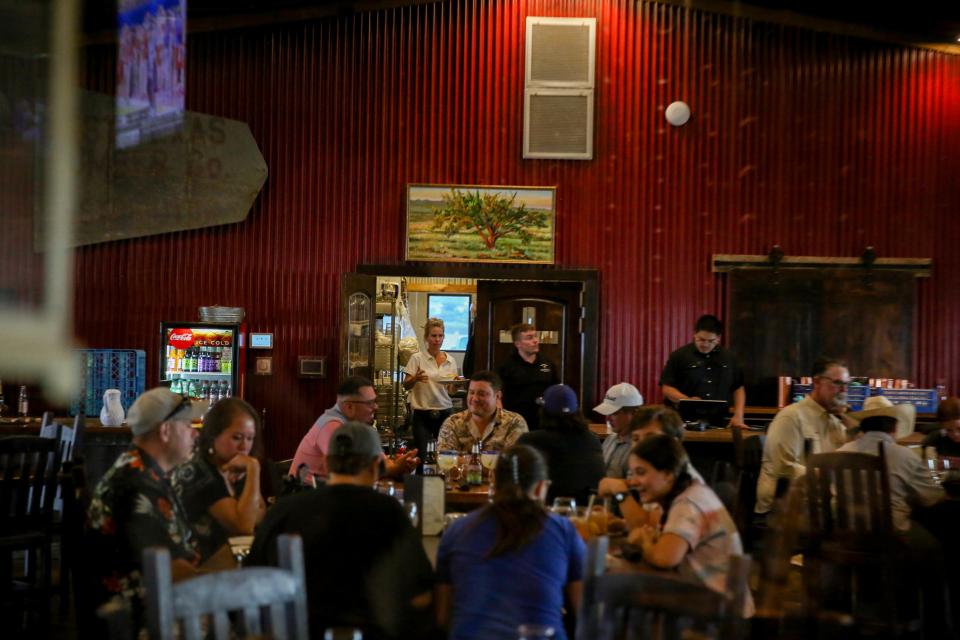 Katherine Parker delivers food at her Spicewood Bar and Restaurant in Alpine, Texas. A labor shortage in the town has impacted businesses in the hospitality industry.