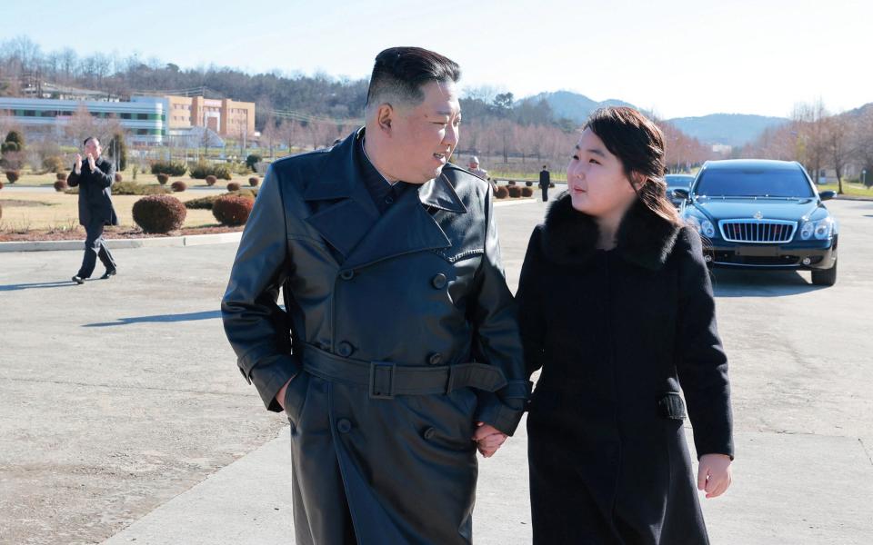 Dressed in a black coat with a fur collar, the girl – believed to be Kim’s second child, named Ju Ae – can be seen linking arms with her father - KCNA/Reuters