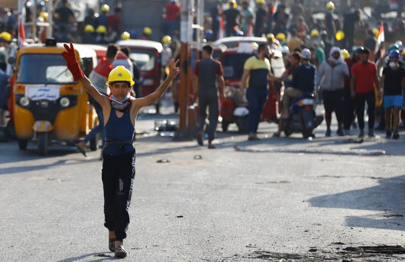 A young demonstrator flashes the victory sign during ongoing anti-government protests, in Baghdad