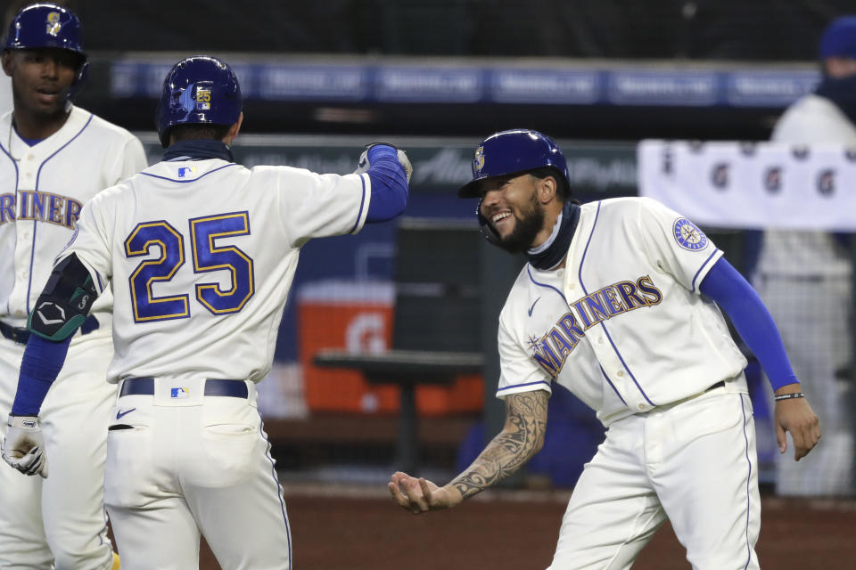 Seattle Mariners' Dylan Moore (25) is congratulated by J.P. Crawford after Moore's two-run home run against the Colorado Rockies during the first inning of a baseball game Sunday, Aug. 9, 2020, in Seattle. (AP Photo/Elaine Thompson)